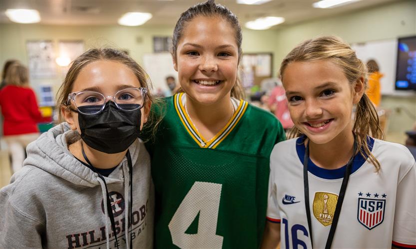 Three students smile